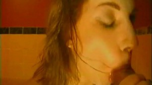 Brunette sucks a cock while sitting in the bathtub 