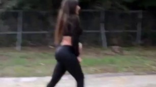 BRUNETTE IN WETLOOK LEGGINGS WALKING