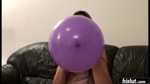 Good looking brunette blowing balloons 