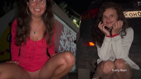 Two girls pissing in public near the car