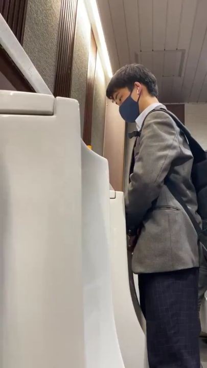 A male student is pissing in the toilet 3.