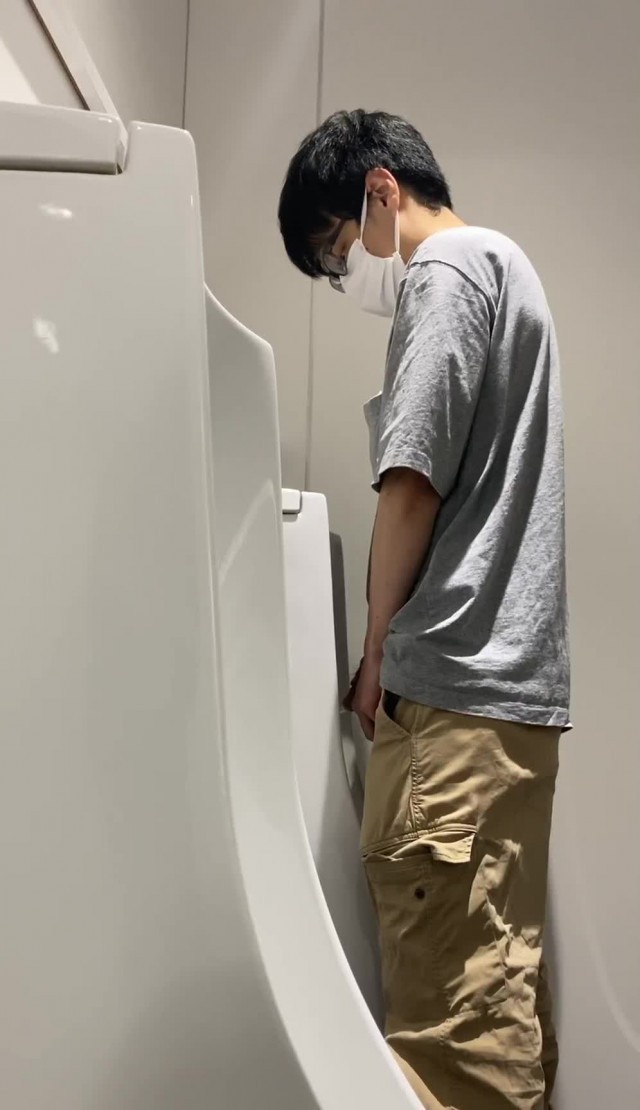 A male student is pissing in the toilet 12.