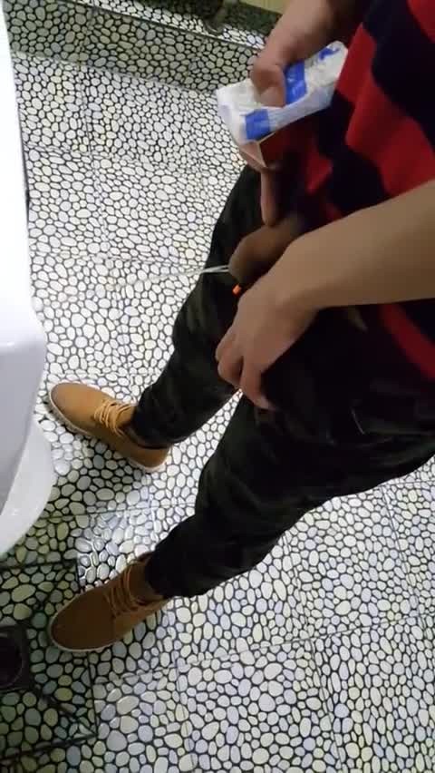 A male is pissing in the toilet 20.